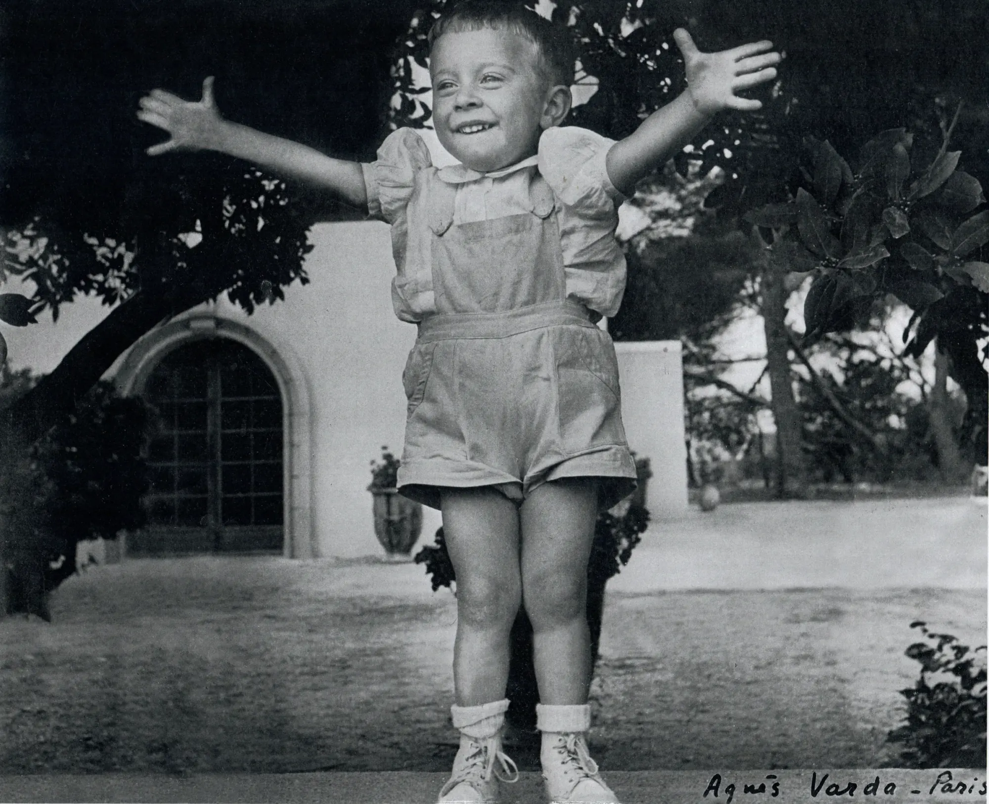 Édouard as a child, arms wide open in front of the sheepfold — photograph by Agnès Varda, 1952